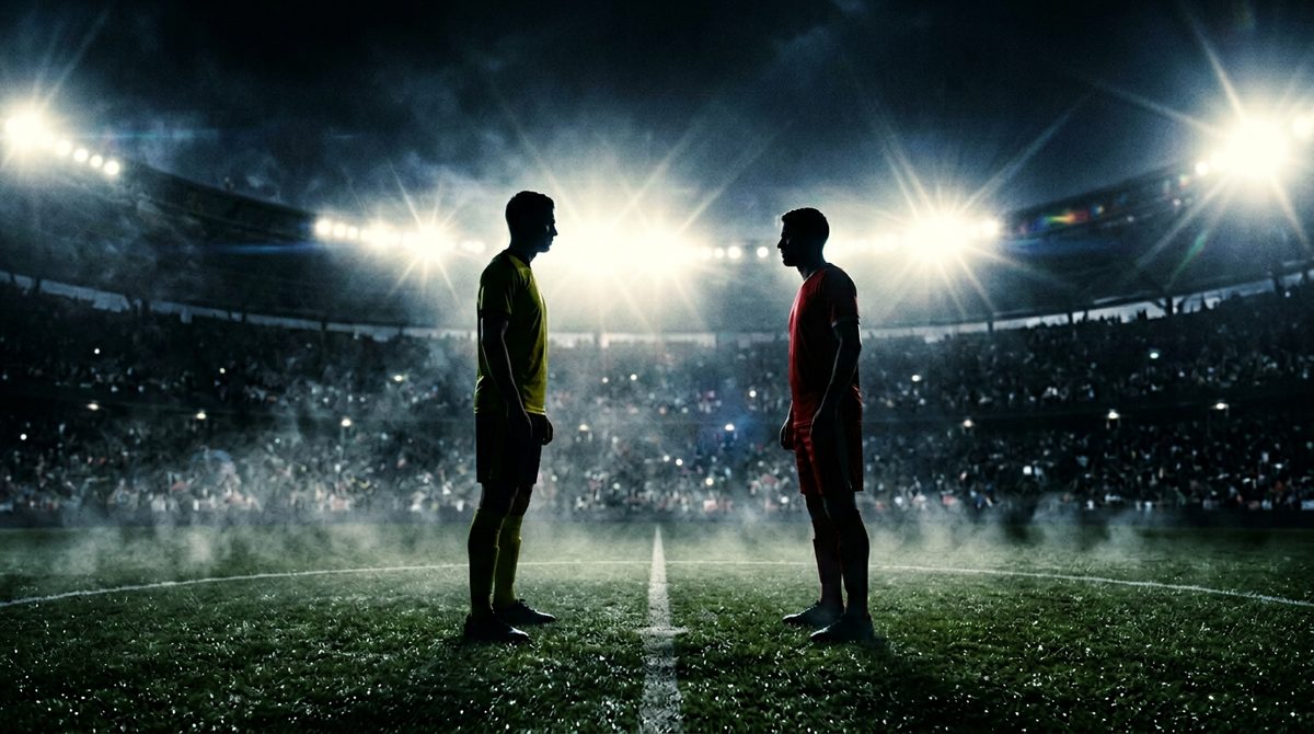 Silhouette of two football players facing each other under floodlights before a World Cup 2026 match